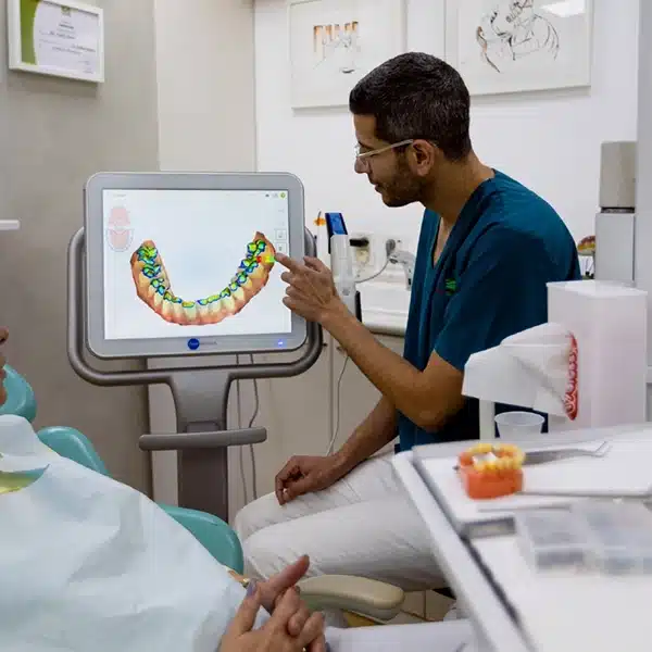 דר פתחי Calma Clinic מראה צילום שיניים למטופל על מסך